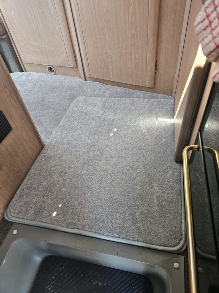 Motorhome entry way with new carpet  with bound edges and a complimentary mat on top